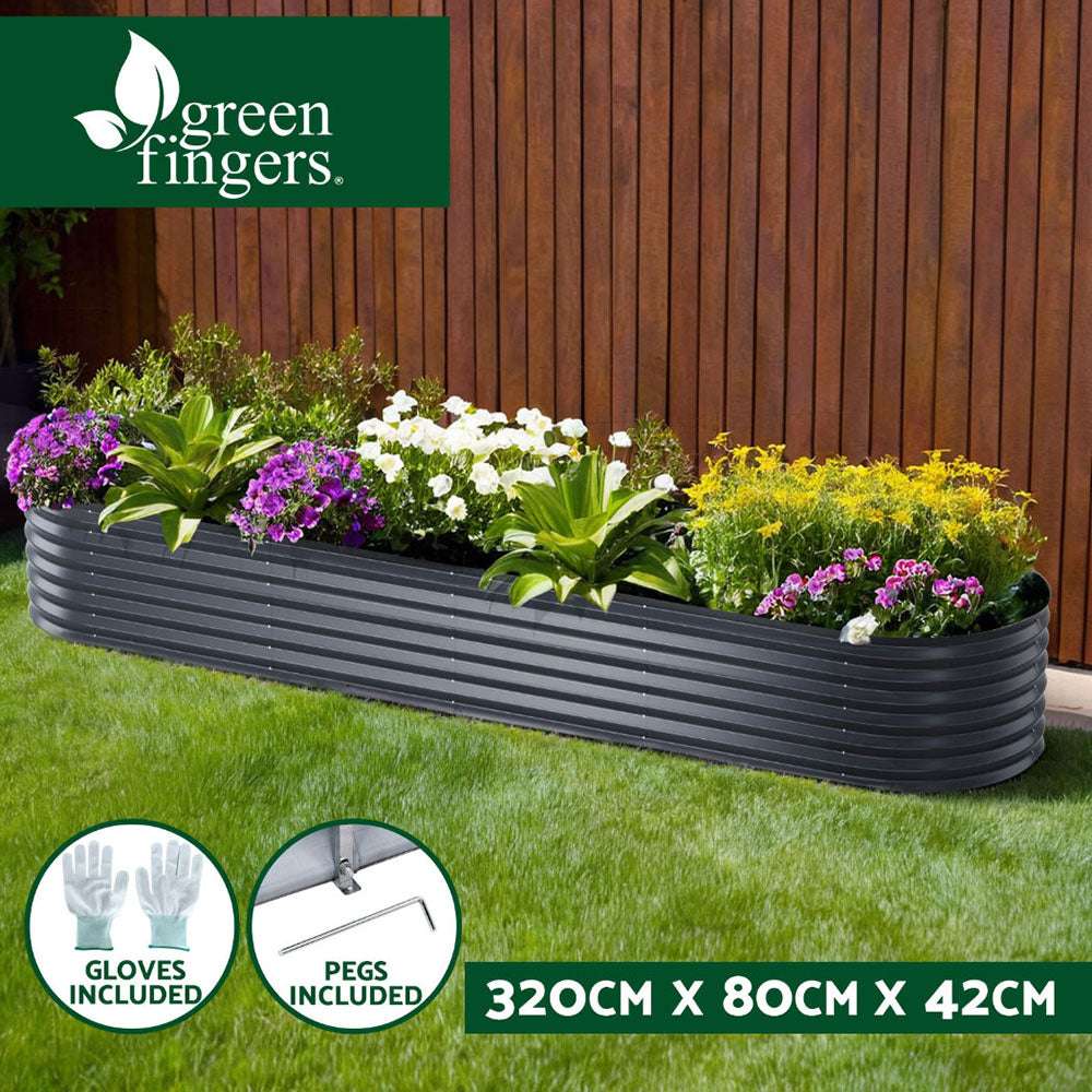 Raised garden bed with flowers and greenery against fence