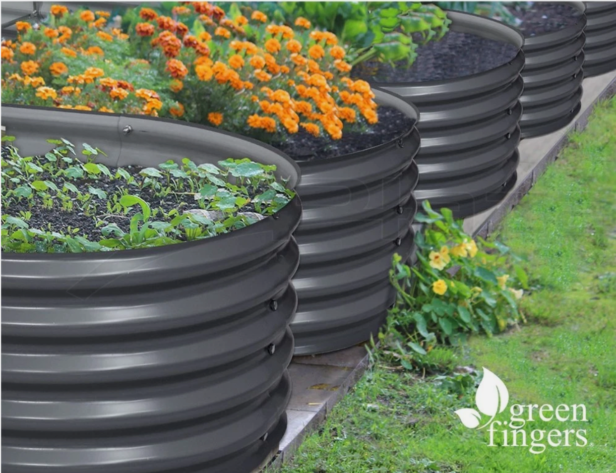 Round raised garden bed filled with flowers and soil